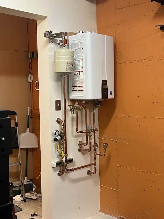 Plumbing technician inspecting water heater connections in Glendale Heights